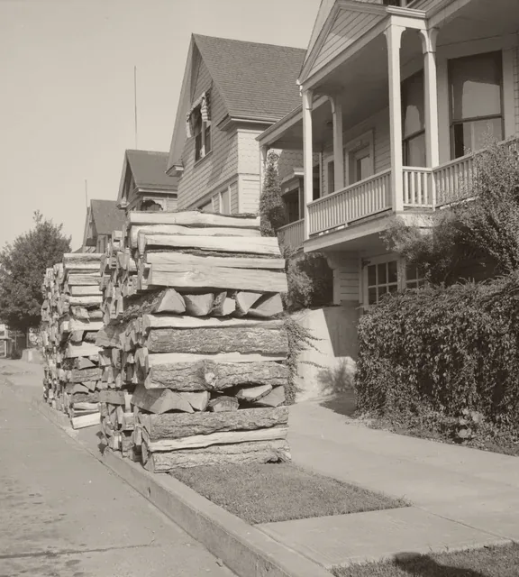 Firewood stacked along a Portland, Oregon street in 1939. Photograph by Dorothea Lange.